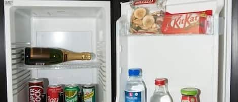 Un réfrigérateur ouvert contenant diverses boissons et collations.