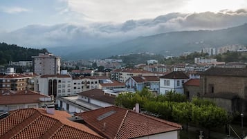 Un pueblo rodeado de colinas y montañas, con edificios de tejados rojos.