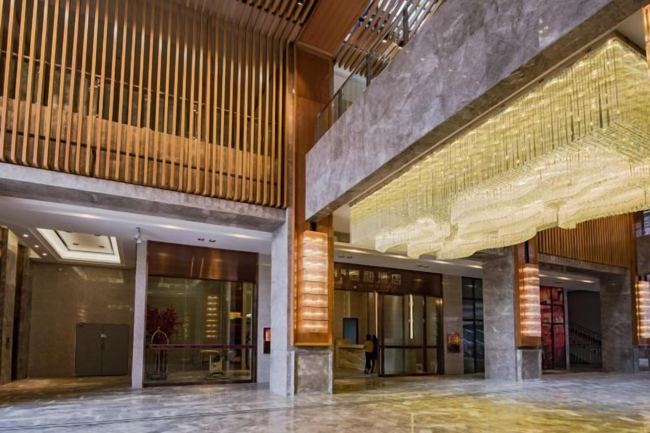 A spacious lobby with a high ceiling, large windows, and a modern design.