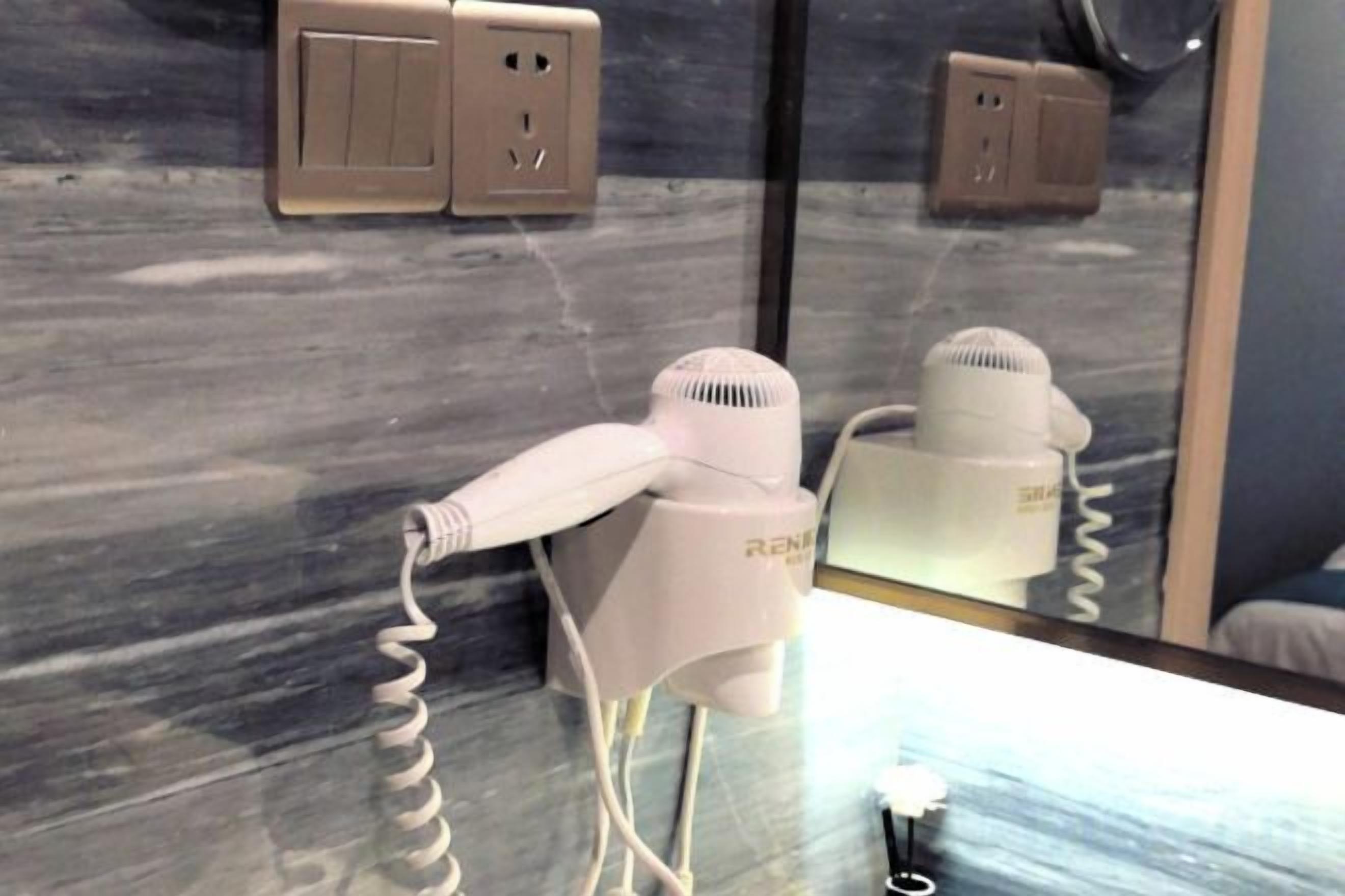 Un secador de pelo y un cargador de teléfono sobre una mesa.