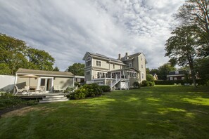 A large two-story house with a covered patio and a spacious backyard. - Charming apartment with 12 foot ceilings, fireplaces, and lots of sunshine. (Newport)