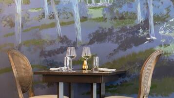 Una mesa de comedor con dos sillas y un cuadro de una cascada en la pared de fondo.