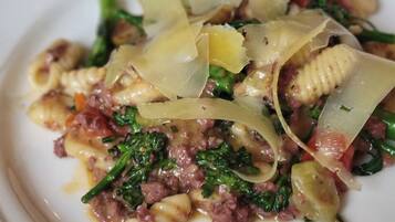 A plate of pasta with greens and cheese.