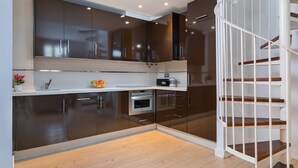 A modern kitchen with dark cabinets, a white countertop, and a built-in oven. - Holiday Rentals Tempa Museo (Seville)