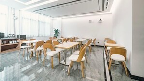 A modern conference room with white walls, wooden chairs, and a marble floor. - Zhenjiang July hotel (Zhenjiang)