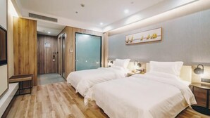 A hotel room with two beds, a wooden floor, a painting on the wall, and a TV on the left. - Zhenjiang July hotel (Zhenjiang)
