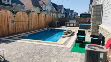 Alberca techada, alberca al aire libre y camastros