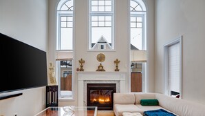Un salón amplio con chimenea, un televisor de pantalla plana grande y una zona de estar confortable.