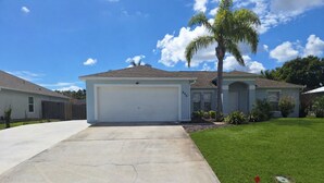 A residential house with a garage, a driveway, and a well-maintained lawn.