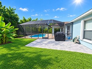 A backyard with a swimming pool, covered patio, and a grill area. - ☆☀︎❀ Tropical Paradise! Heated Pool, Boat Parking, Near Beaches! (Sebastian)