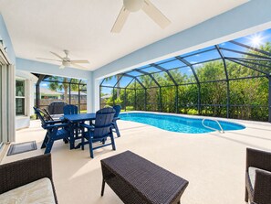 An indoor pool area with a glass enclosure, a table with chairs, and a ceiling fan. - ☆☀︎❀ Tropical Paradise! Heated Pool, Boat Parking, Near Beaches! (Sebastian)