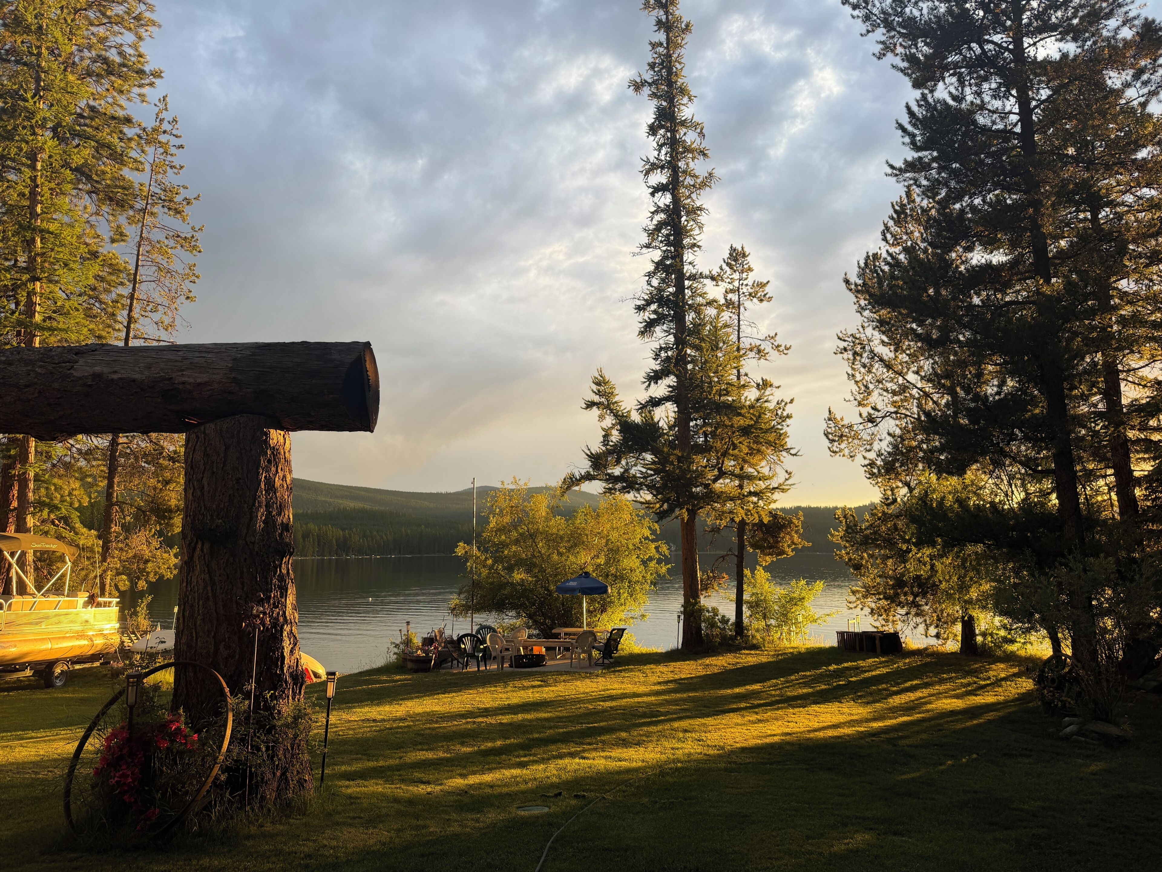 A lakeside setting with a wooden structure, a bicycle, and outdoor seating.