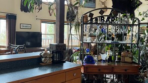 A spacious living area with a wooden cabinet, a coffee machine, and a plant shelf. - Lakefront home on McGregor Lake<br>Marion, Montana  (Marion)