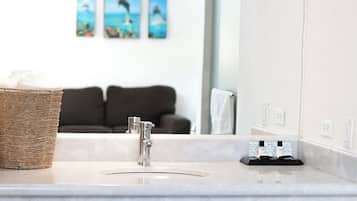 A bathroom with a sink, a mirror, a towel rack, and a basket.