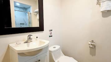 A bathroom with a white sink, a toilet, a mirror, and a towel rack.