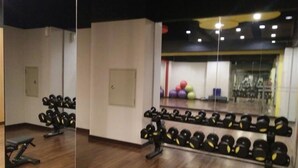 A gym with wooden flooring, weightlifting equipment, and a mirrored wall. - Cozy and Modern Signature Park Grande Studio Apartment (Jakarta)