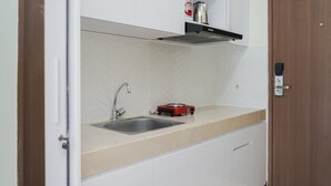 Een keuken met een dubbele spoelbak, een rode inductiekookplaat en witte kastjes.