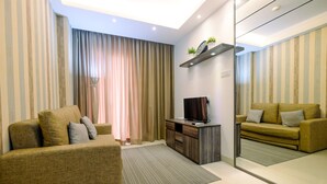 Un salon moderne avec un canapé, un meuble pour la télévision et un miroir.