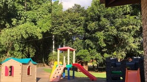 Un parque infantil con una estructura para escalar, toboganes y casitas de juegos.