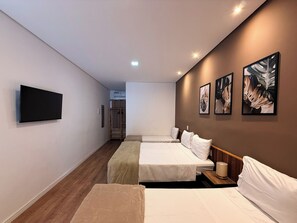 Habitación de hotel con dos camas, un televisor de pantalla plana, obras de arte en la pared y un armario vestidor.