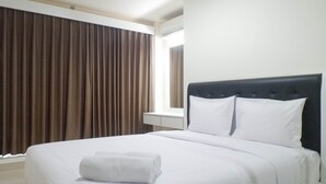 A hotel room with a bed, white linens, a neatly folded towel, a window with curtains, and a white nightstand. - Exquisite 1BR at Praxis Apartment (Surabaya)