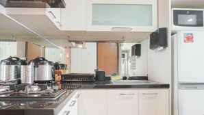 A modern kitchen with a gas stove, stainless steel appliances, and a refrigerator. - Attractive 1BR Apartment at Royal Olive Residence (Jakarta)