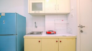 Une cuisine de taille réduite avec un réfrigérateur bleu, un évier et une cuisinière électrique rouge.