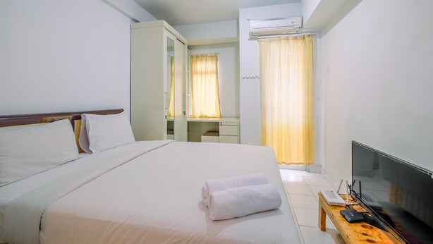 Une chambre d’hôtel équipée d’un lit, d’un bureau, d’une télévision et d’un appareil de climatisation.