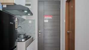 Een keuken met een fornuis, kastjes en een dubbele deur met een bordje.