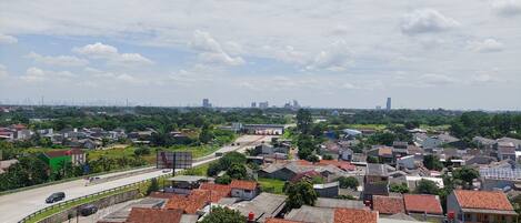 Zona residencial con casas, una calle y un horizonte lejano de la ciudad.