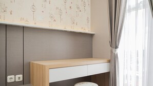 Een moderne kamer met een houten bureau, een witte kruk en een muur met decoratieve patronen.