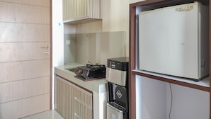 A compact kitchen with a refrigerator, a coffee machine, and a microwave.