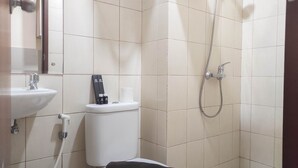 A small bathroom with a toilet, sink, and shower.