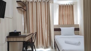 A hotel room with a bed, a desk, and a chair.