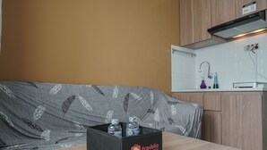 A kitchenette with a wooden countertop, a sink, and a faucet. There is a black box labeled "Travelio" on the countertop. - Restful and Tidy 2BR at Green Pramuka City Apartment (Jakarta)