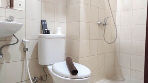 A bathroom with a toilet, a sink, and a shower. - Comfort Studio at Vida View Makasar Apartment (Makassar)
