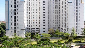 A high-rise residential building with multiple floors, balconies, and a central courtyard with greenery and a spherical structure. - Simple and Cozy Living Studio Room at Bassura City Apartment (Jakarta)
