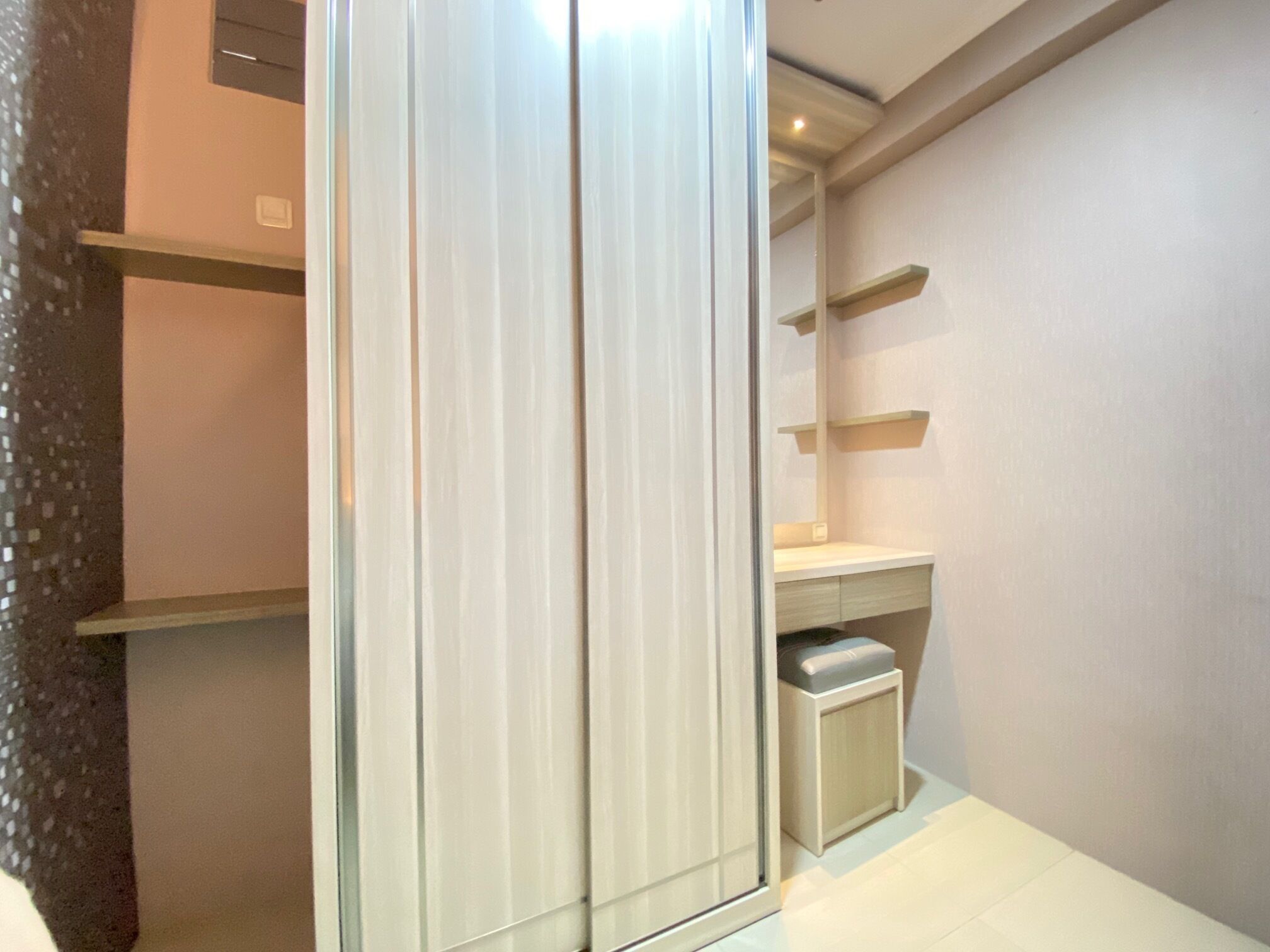 Un baño moderno con cabina de ducha de vidrio, un lavabo blanco y un mueble de tocador pequeño con espejo.