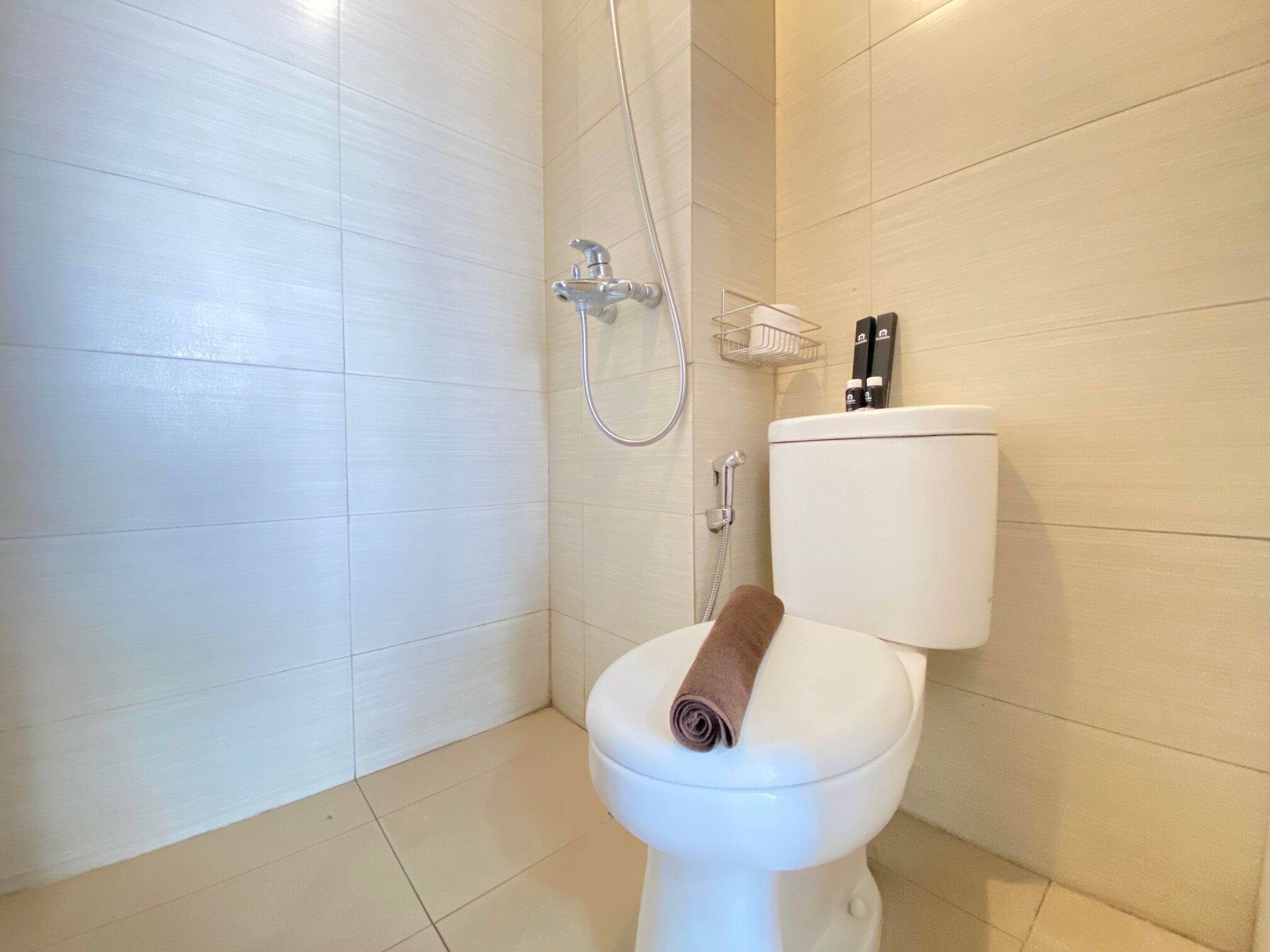 Ein Badezimmer mit Toilette, Dusche und Toilettenpapierhalter.