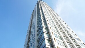 Un edificio moderno y alto con un cielo despejado al fondo.