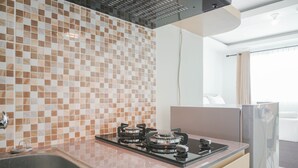 A modern kitchen with a tiled backsplash, stainless steel appliances, and a large window.