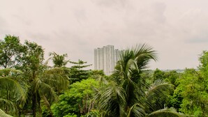 Un immeuble de grande hauteur entouré d’une végétation tropicale luxuriante.