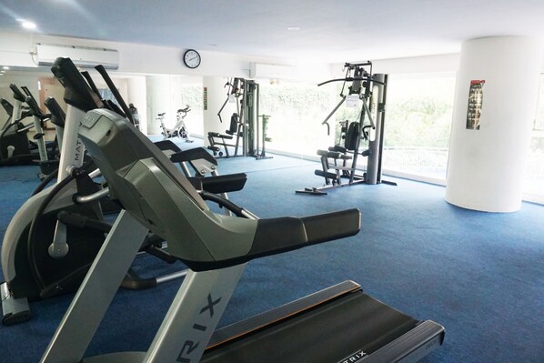 A gym with treadmills, stationary bikes, and weight machines.