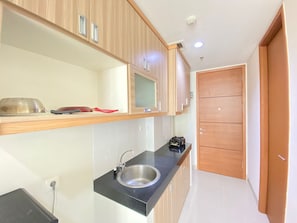 Fridge, stovetop, cookware/dishes/utensils - Stylish & Comfy Studio at Dago Suites Apartment (Bandung)