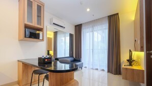 Una cocina moderna con una isla central, taburetes de bar, microondas integrado y equipo de aire acondicionado.