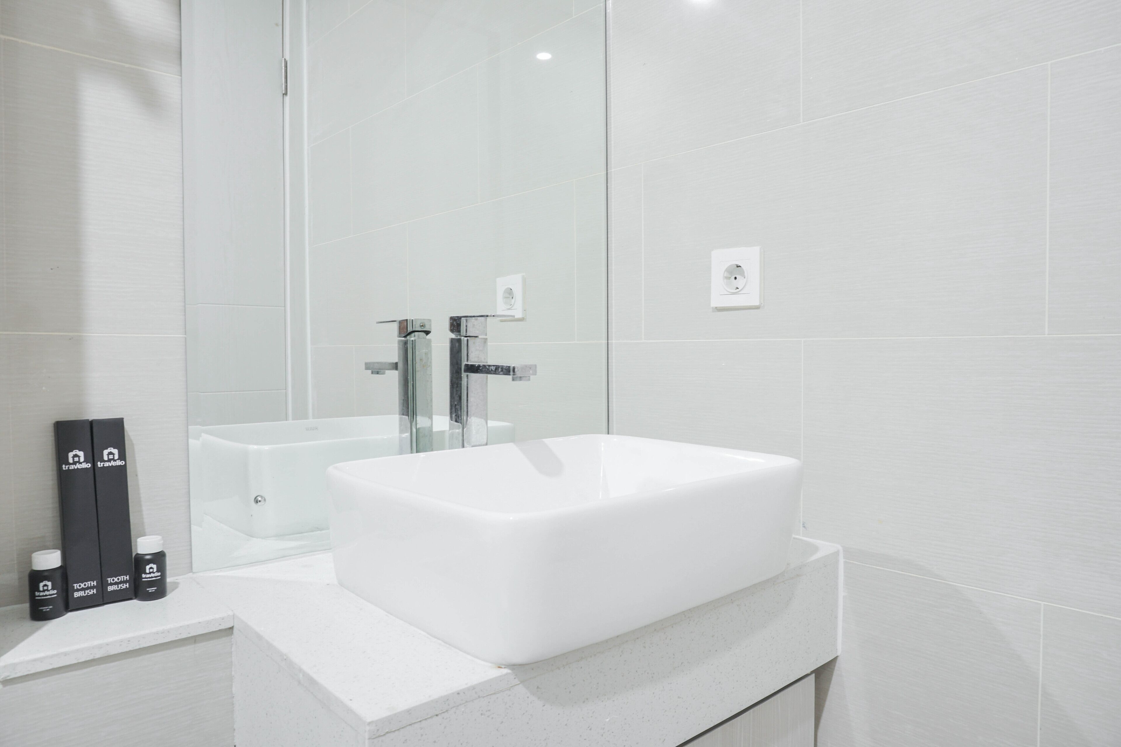 Ein modernes Badezimmer mit einem großen weißen Waschbecken, einer Duschkabine aus Glas und einem Spiegel.