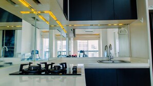 A modern kitchen with a gas stove, a sink, and a large mirror above the counter.