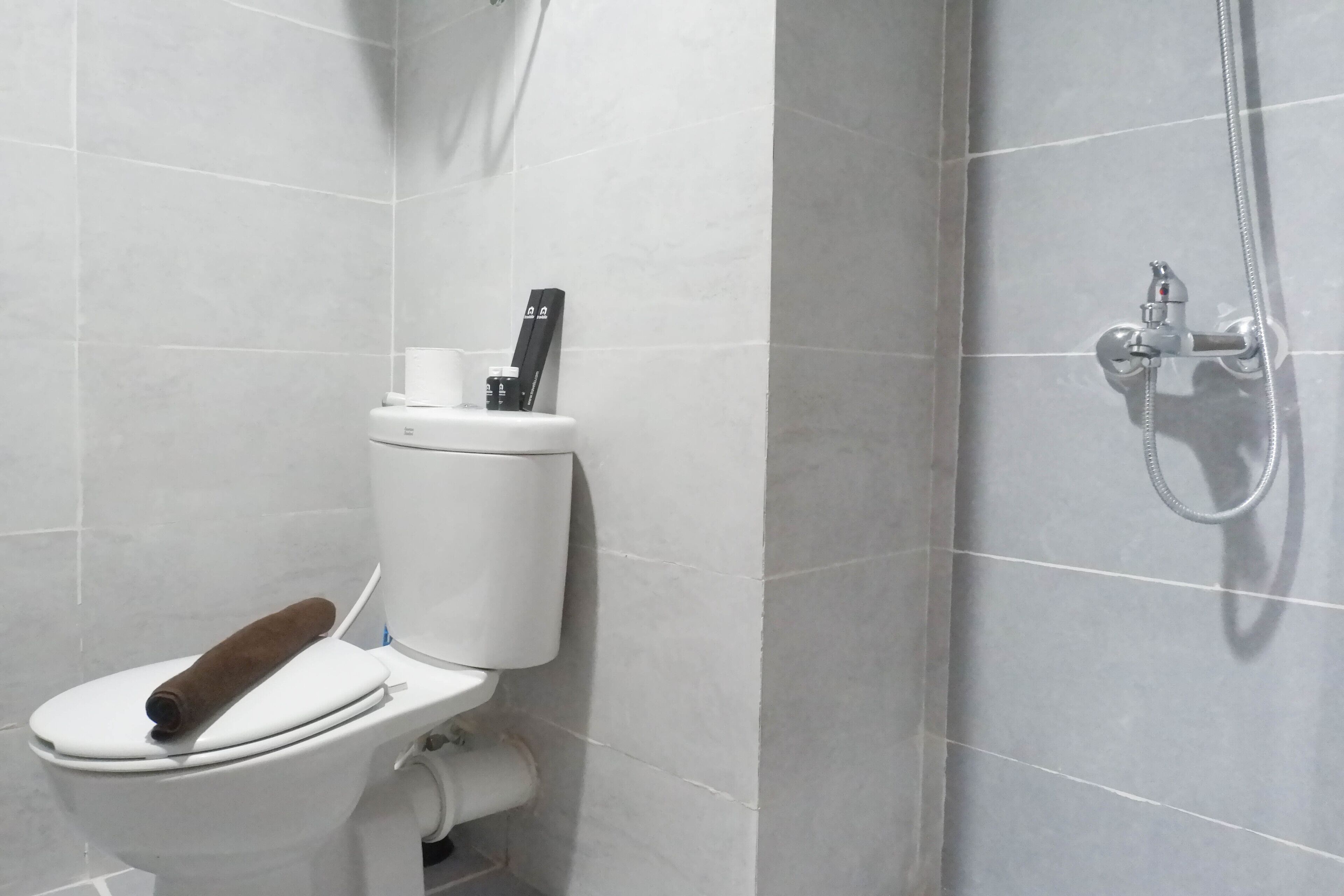 Un baño moderno con inodoro, ducha y toallero.