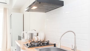 Una cocina moderna con un lavamanos de acero inoxidable, una estufa a gas y una campana extractora.