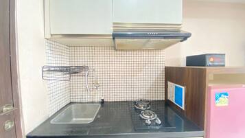 A kitchen with a gas stove, a sink, and a microwave.